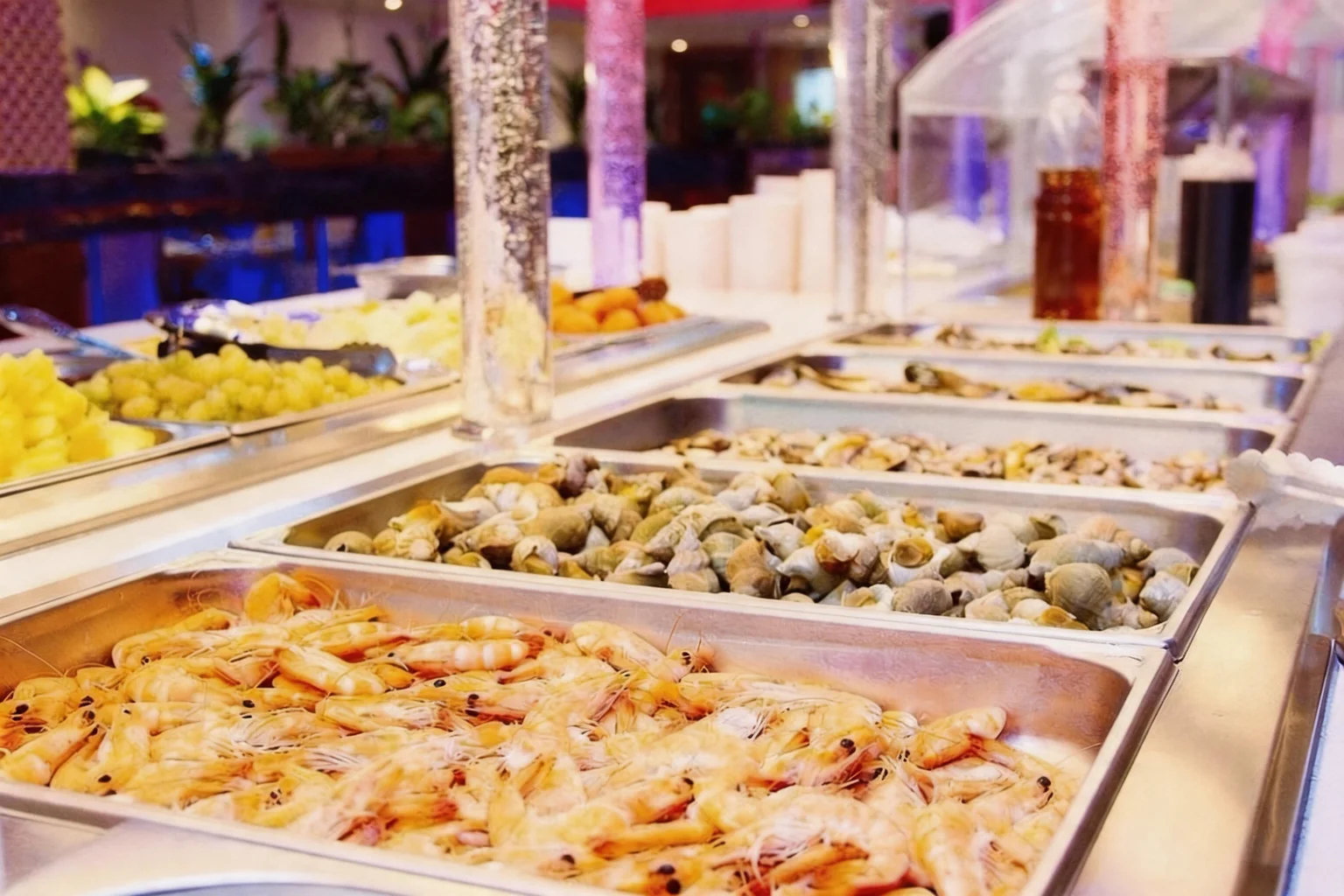 Crevettes et coquillages dans des bacs en inox du buffet